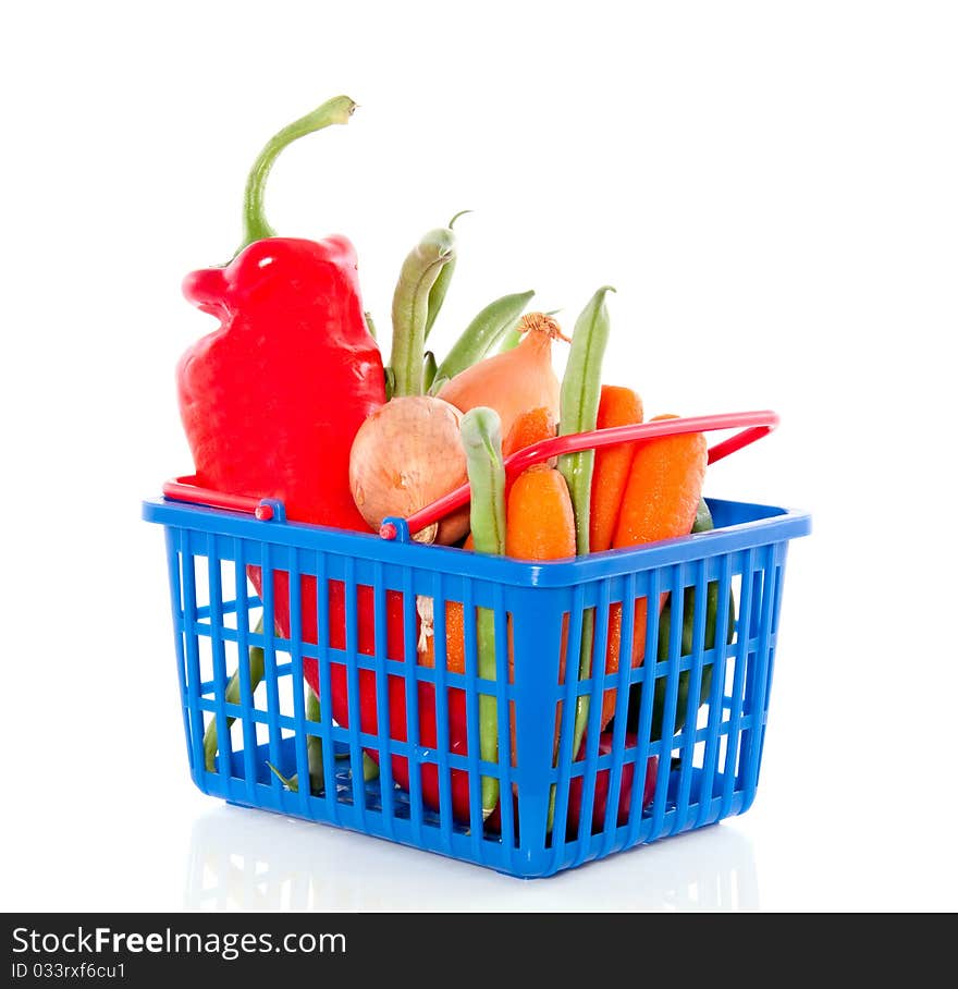 Fresh vegetables in a plastic shopping basket isolated over white