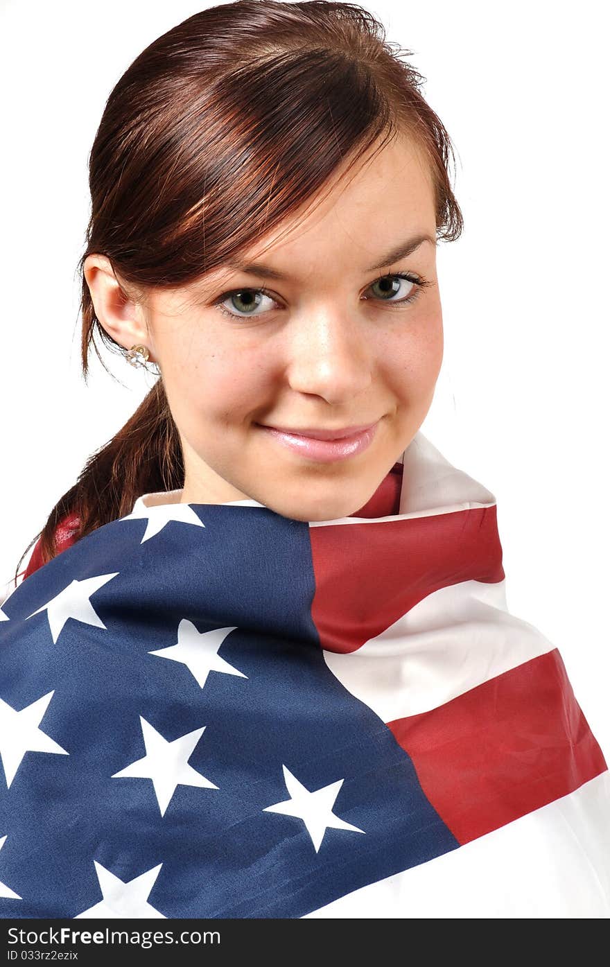 Girl wrapped in American flag looking content. Isolate taken in the studio