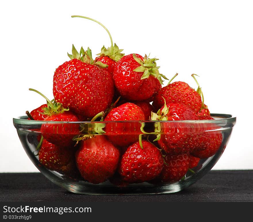 Glass bowl with strawberries on a white background