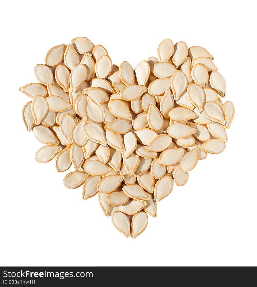 Heart from pumpkin seeds isolated on white