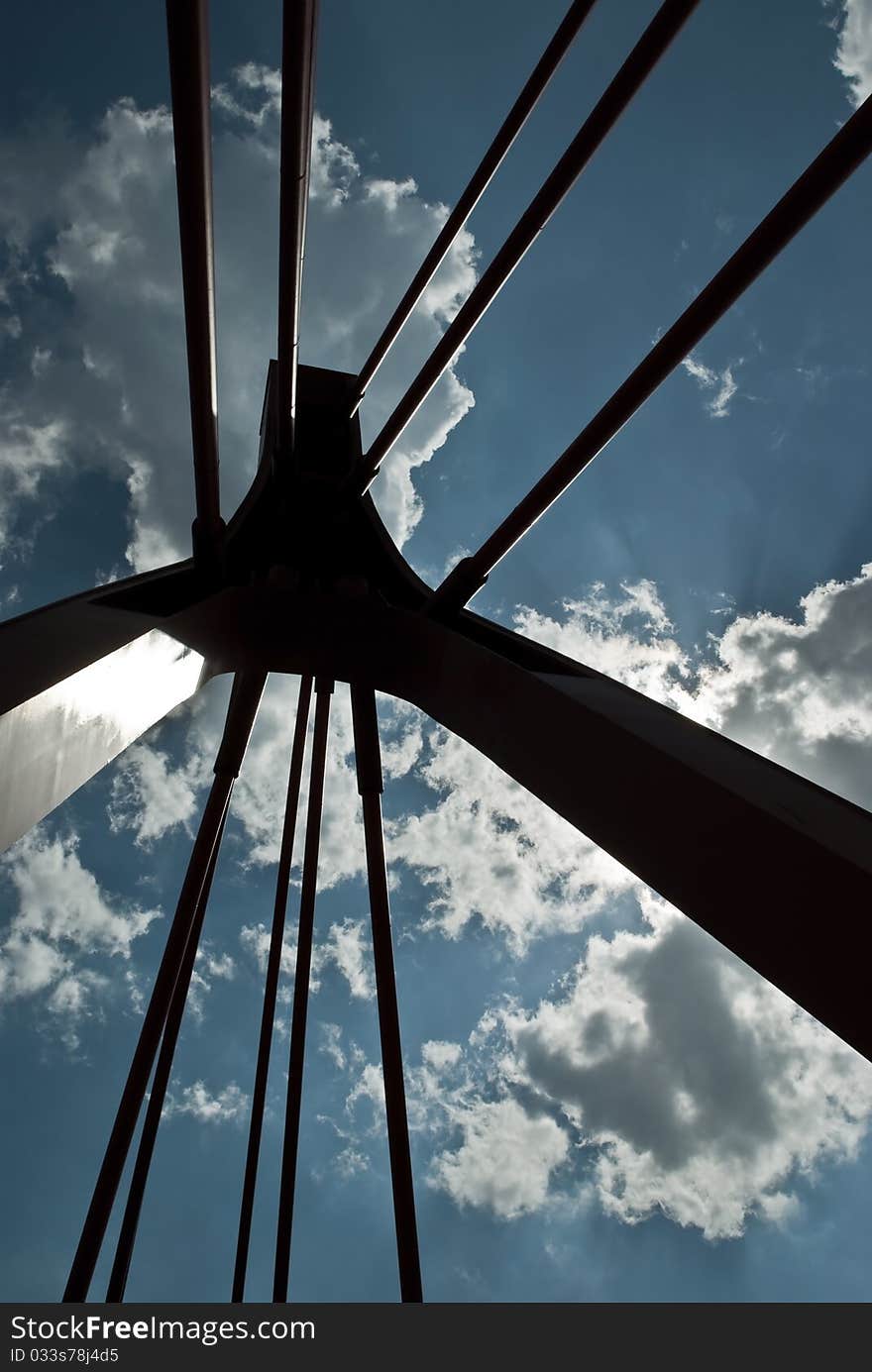 Bridge pylon with cables against the cloudy sky.