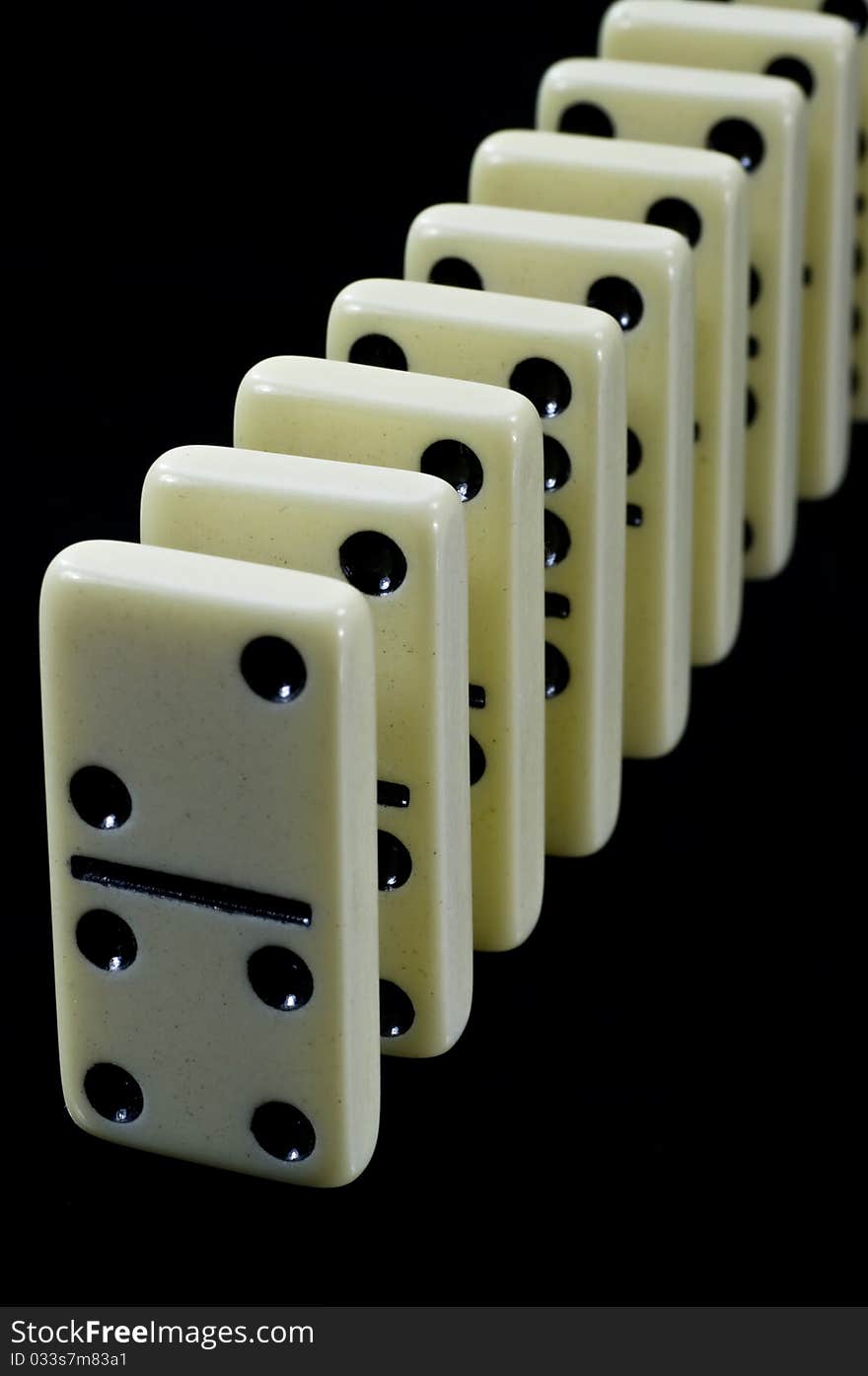 Dominoes waiting to fall, white tiles on black background. Dominoes waiting to fall, white tiles on black background.