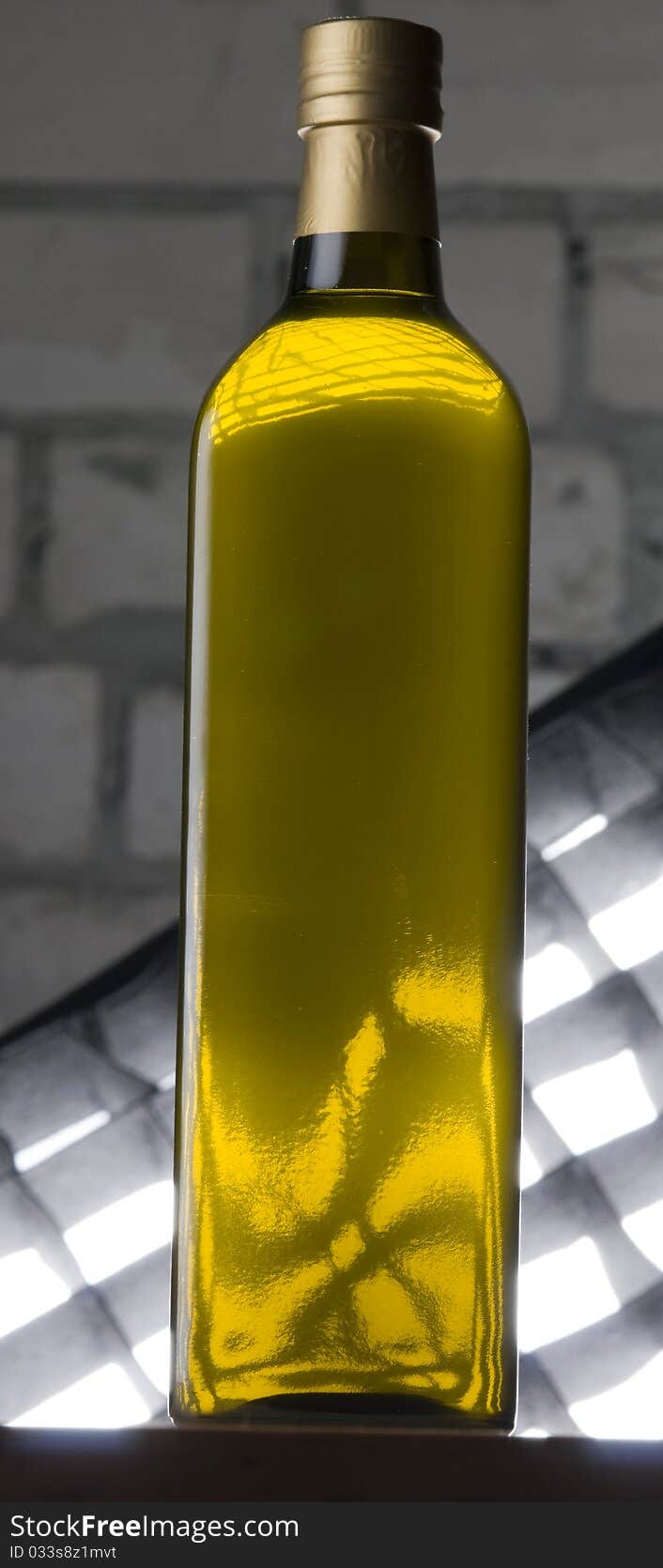 Olive oil bottle still-life over grey brick background