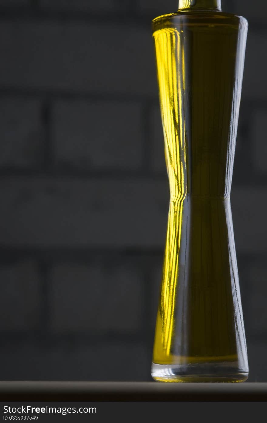 Olive oil bottle still-life over grey brick background