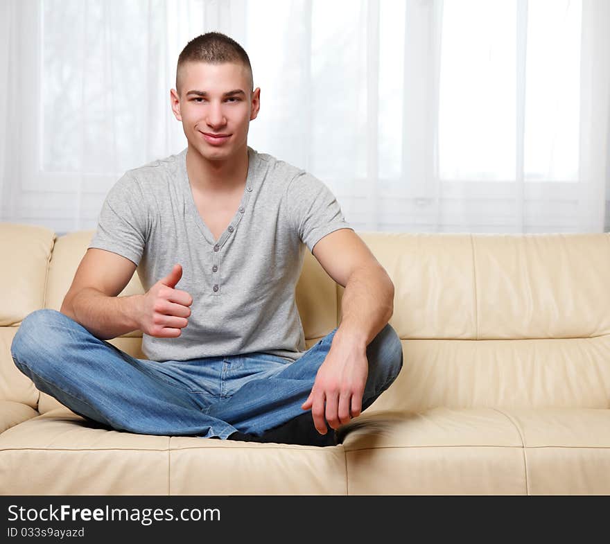 Young man sitting on the sofa. Young man sitting on the sofa