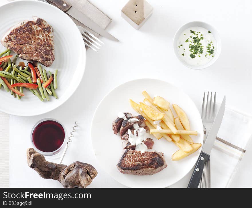 Steak with green vegetables and french fries, view directly from above. Steak with green vegetables and french fries, view directly from above.