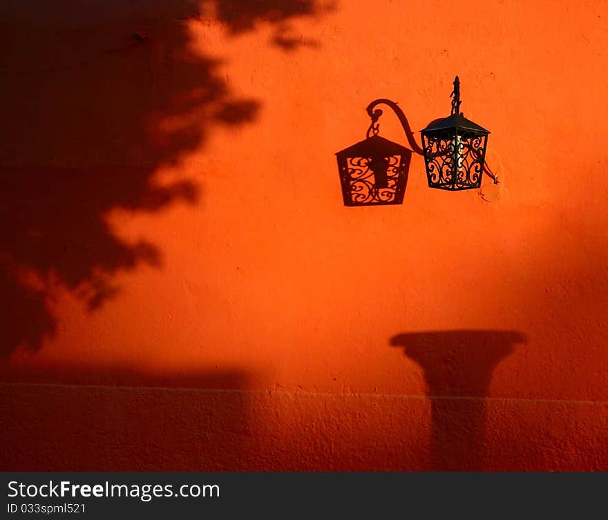 On the bright orange wall hangs a delicate lantern. On the bright orange wall hangs a delicate lantern.