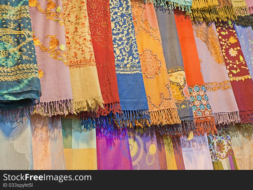 Fabrics and scarves for sale at a market stall. Fabrics and scarves for sale at a market stall