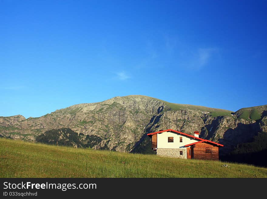 Hut in front of rocky mountain peak. Hut in front of rocky mountain peak