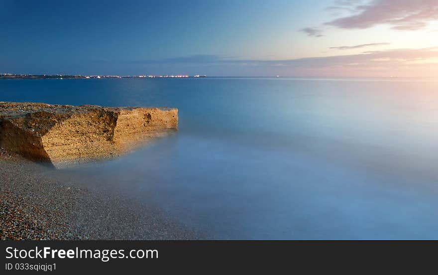 Beautiful seascape. Sea and rock at the sunset. Nature composition.