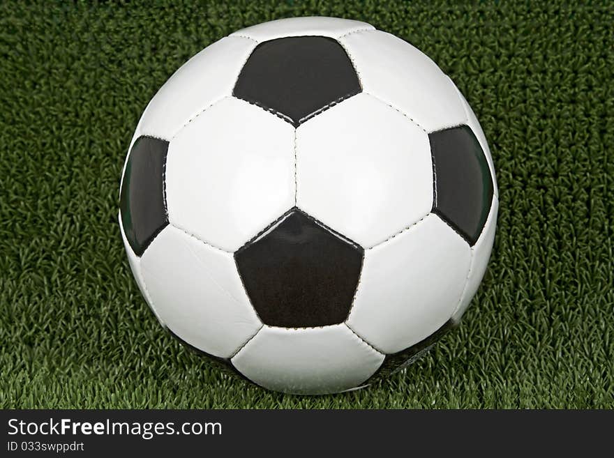 Soccer ball on green soccer meadow.