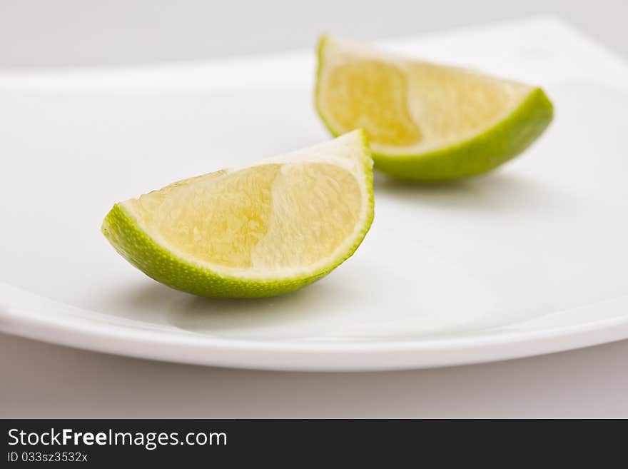 Food series: tasty green sliced lime on plate. Food series: tasty green sliced lime on plate