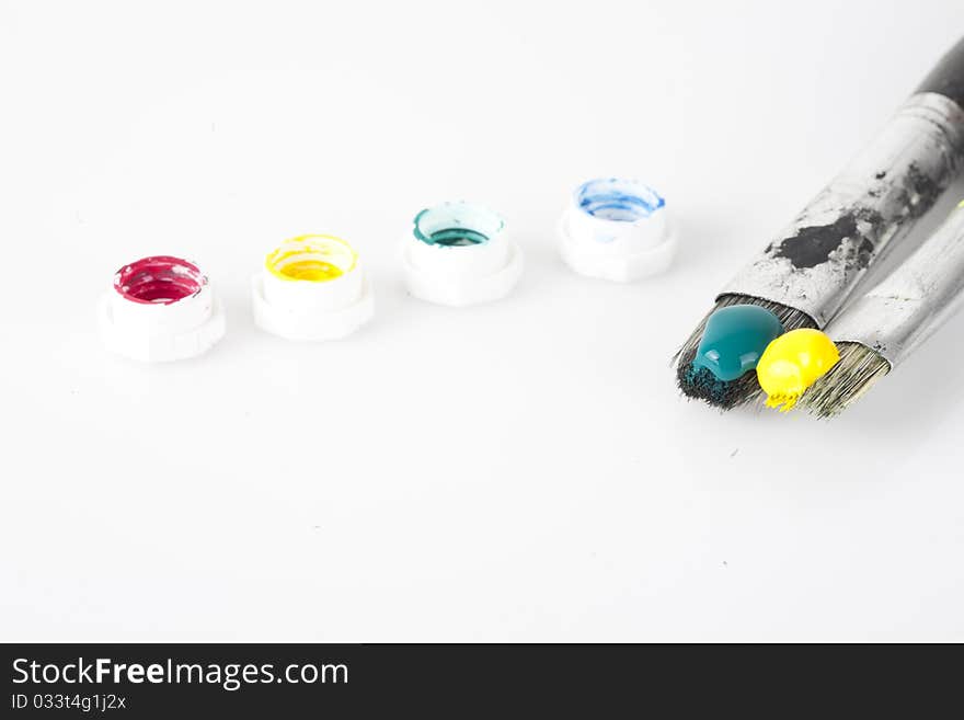 Close up shot on paint brushes isolated on white with paint tube caps