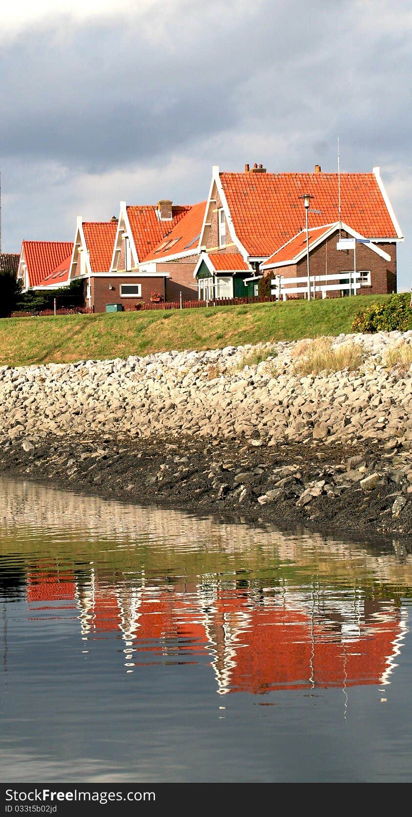 Houses with red roofs reflected in the water