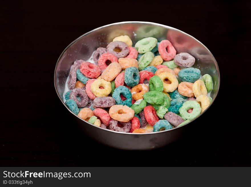 A bowl of looped cerals isolated on black background. A bowl of looped cerals isolated on black background