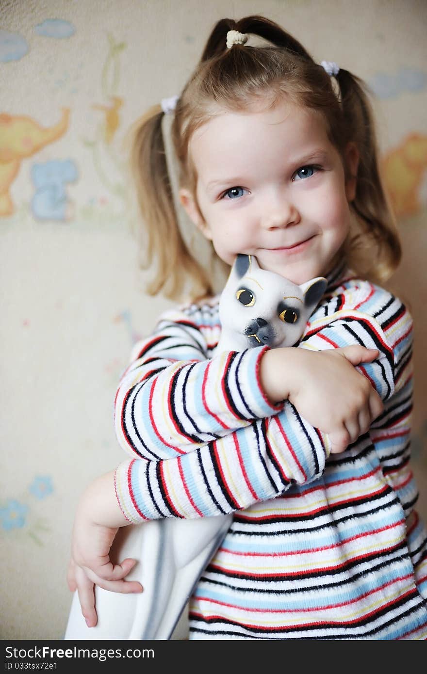 An image of a nice little girl with a toy-cat. An image of a nice little girl with a toy-cat