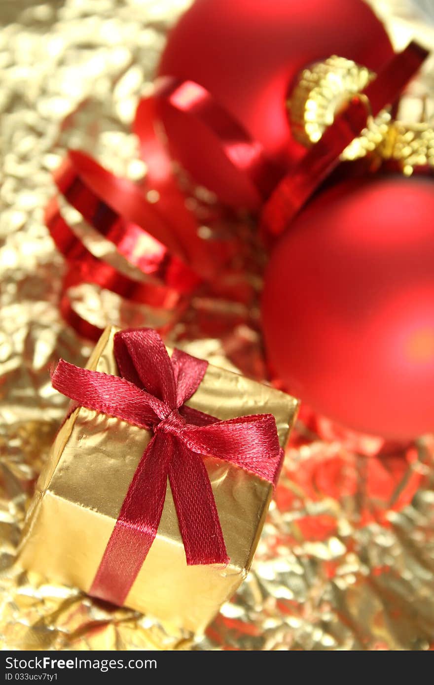 On a gold background red Christmas balls and gift box. On a gold background red Christmas balls and gift box