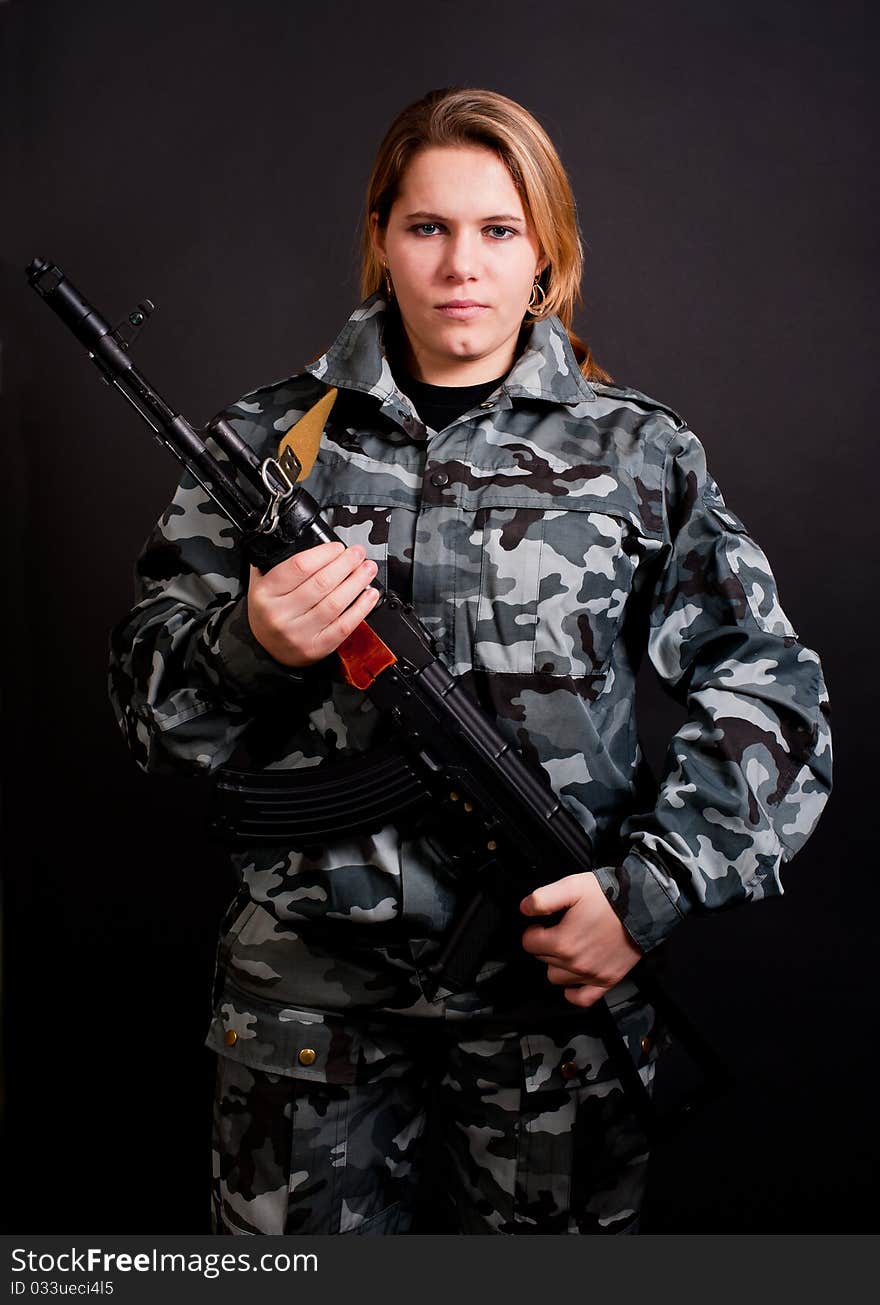 Girl in camouflage clothing holding gun. Girl in camouflage clothing holding gun