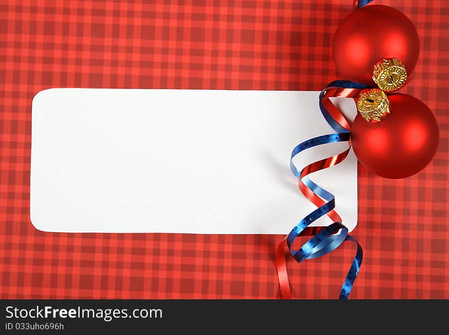 Traditional greeting christmas card with a red background white sheet of paper on which you can write text beside the red Christmas balls and ornaments