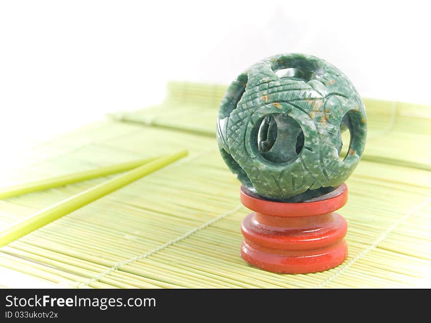 Jade sphere on a green bamboo rug. Jade sphere on a green bamboo rug