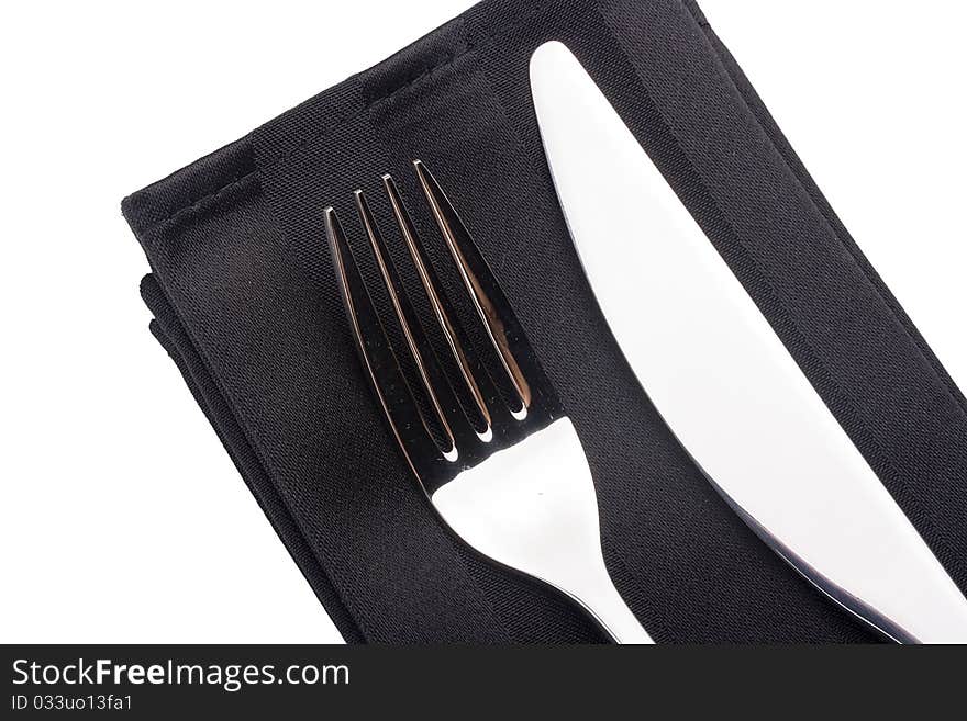 Knife and fork on a black napkin - tableware.