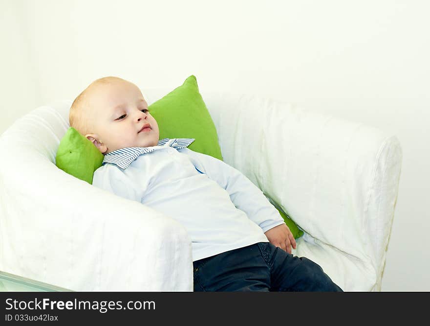 Young caucasian child resting in contemplation on an armchair. Young caucasian child resting in contemplation on an armchair