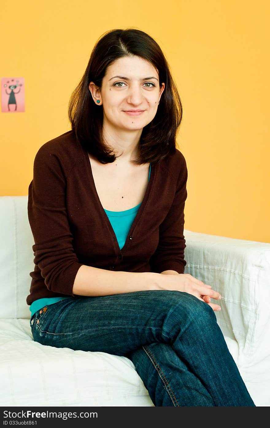 Young woman smiling while resting on a white sofa. Young woman smiling while resting on a white sofa