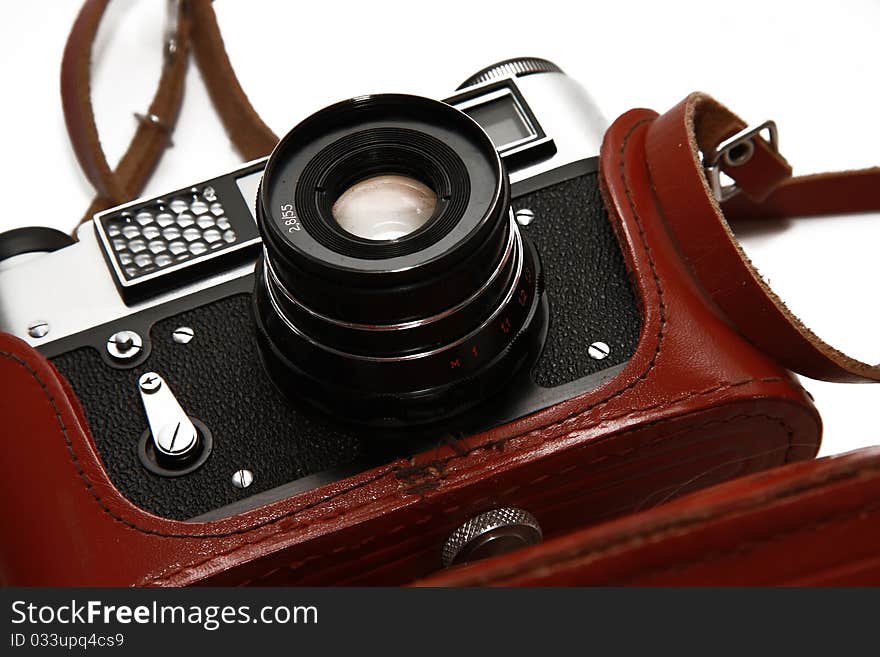 The Soviet film camera in a brown leather case isolated on white. The Soviet film camera in a brown leather case isolated on white