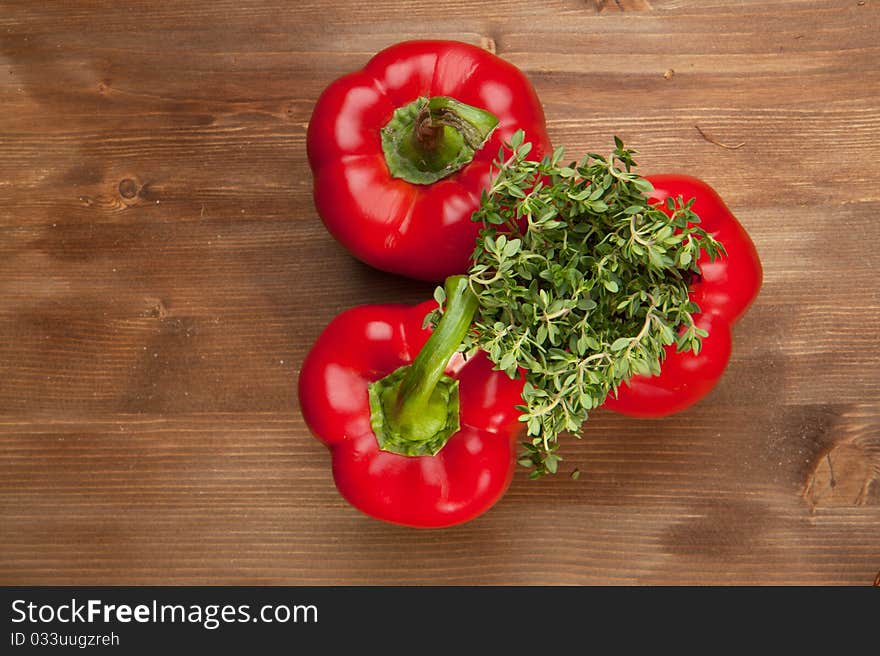 Red paprika withfresh herb on the wooden table. Red paprika withfresh herb on the wooden table