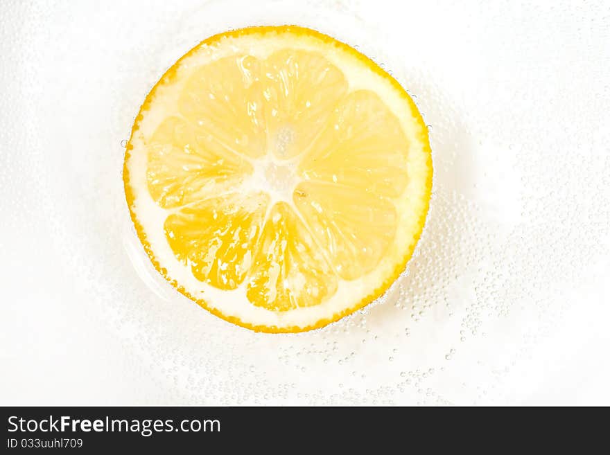 Single cross section of lemon with the bulbs in the water. Single cross section of lemon with the bulbs in the water