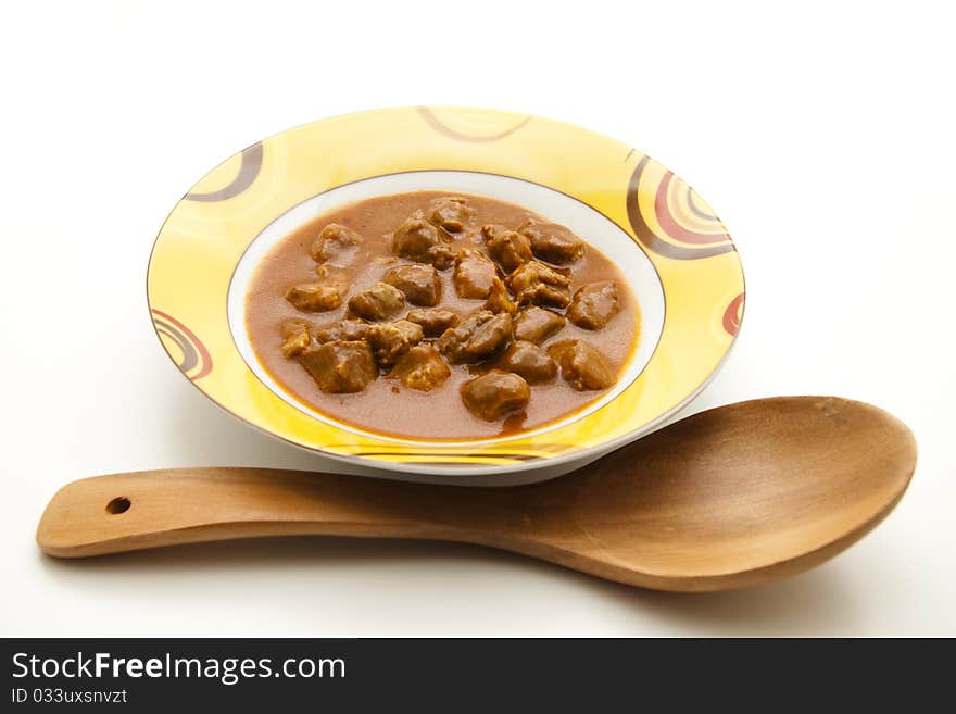 Goulash soup with wooden spoon