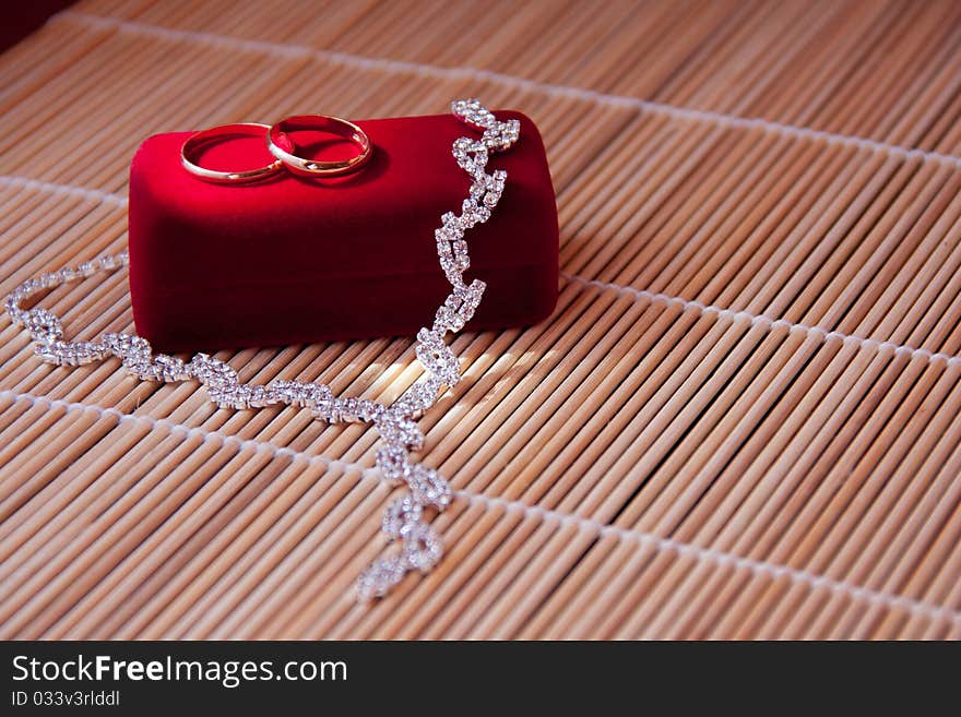 Two wedding rings of gold on the red box on the table. Two wedding rings of gold on the red box on the table