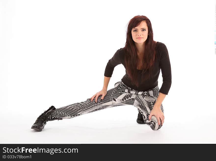 Beautiful female street dancer wearing black and white outfit and black boots, poses on a white backdrop. Beautiful female street dancer wearing black and white outfit and black boots, poses on a white backdrop.