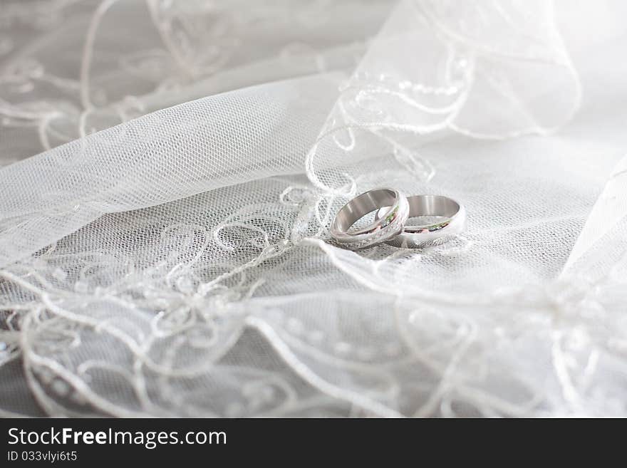 Ring of white gold are on the bride's white veil