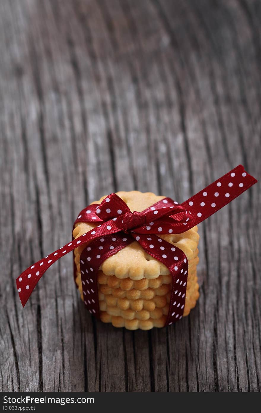 Cookies decorated with dark red polka dots ribbon on the wooden background. Cookies decorated with dark red polka dots ribbon on the wooden background