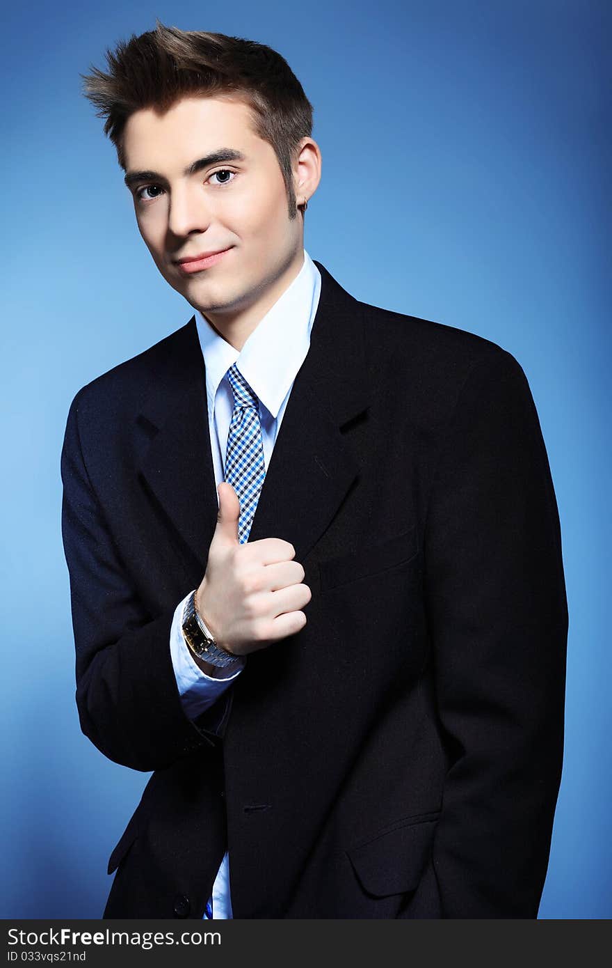 Portrait of a young businessman posing over grey background.