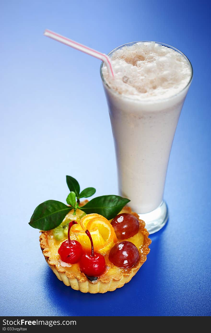 Milkshake and cake on a blue background. Milkshake and cake on a blue background