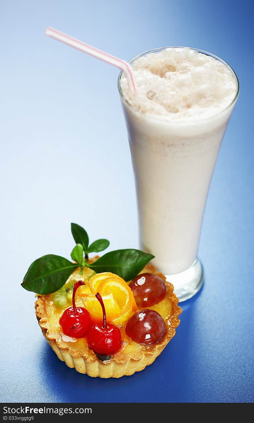 Milkshake and cake on a blue background. Milkshake and cake on a blue background