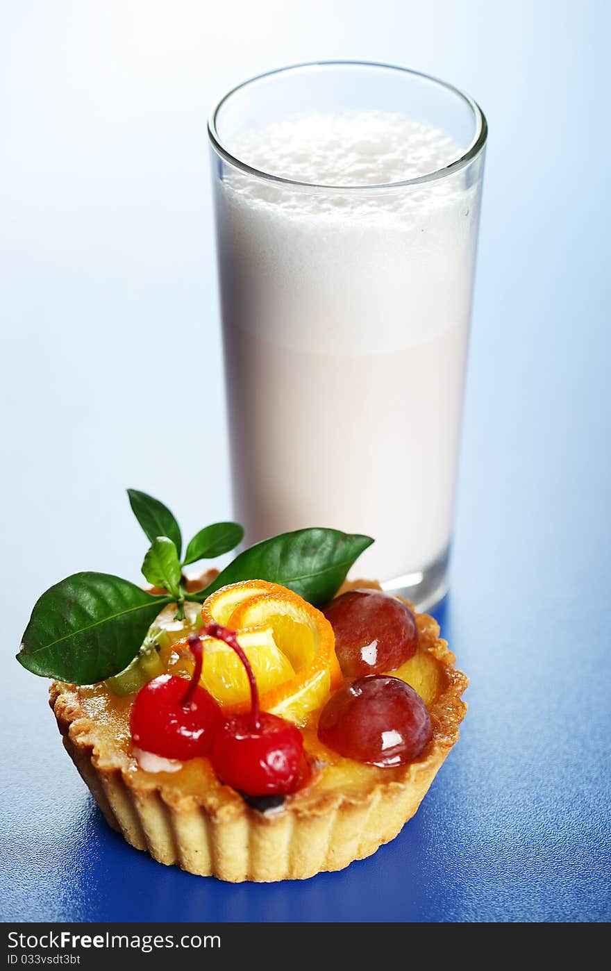 Milkshake and cake on a blue background. Milkshake and cake on a blue background