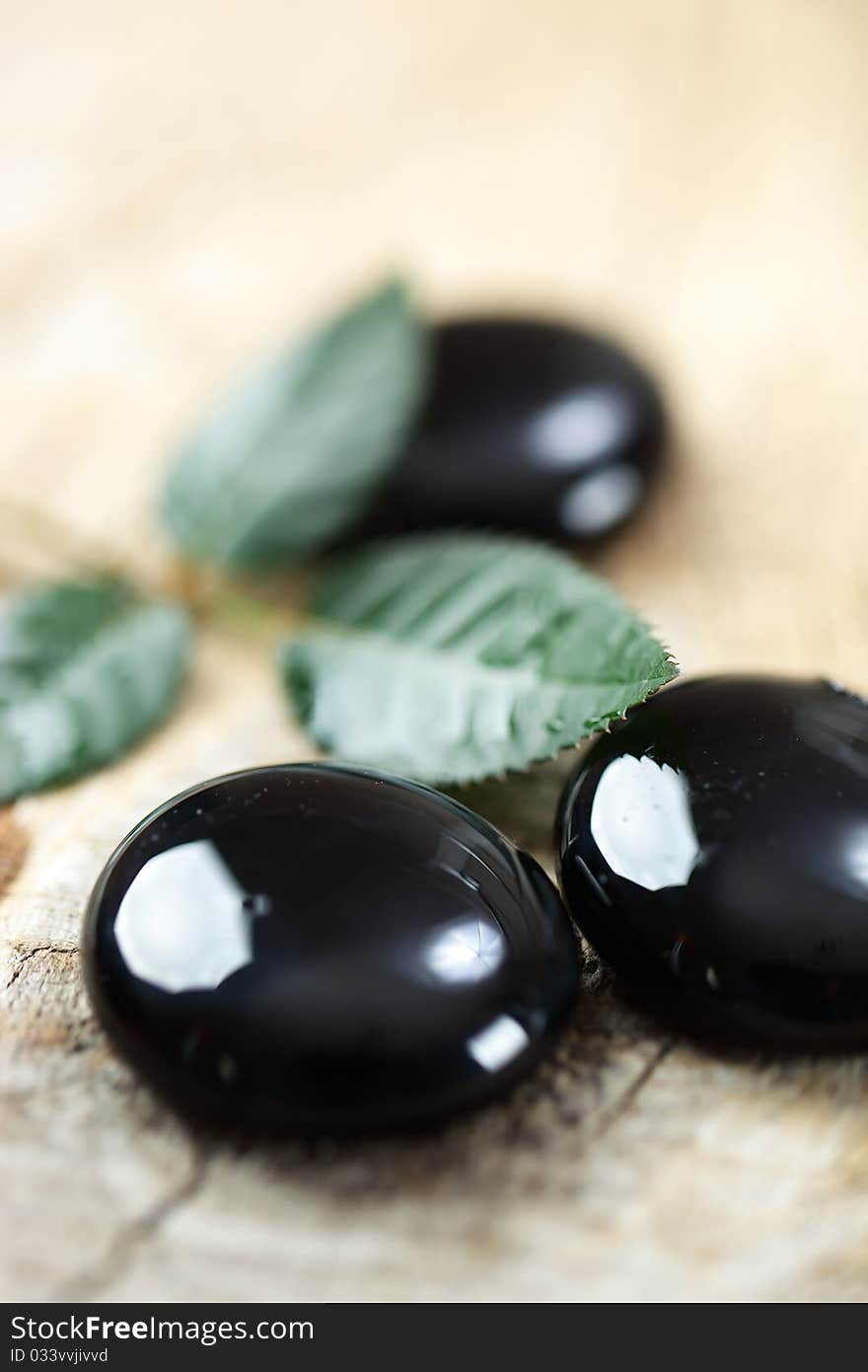 Black massage stones with leaves