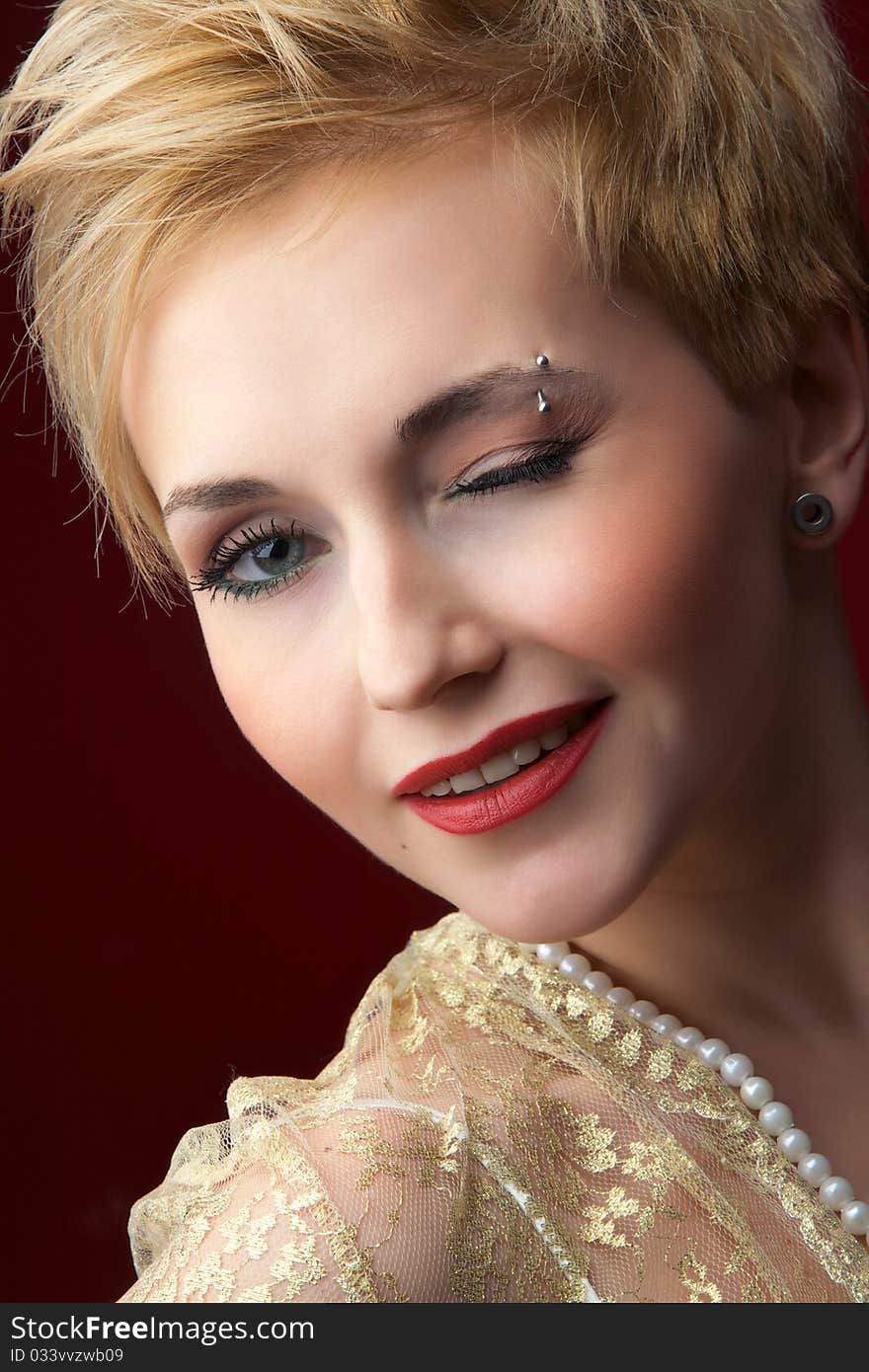 The beautiful girl in a pearl necklace on a red background. The beautiful girl in a pearl necklace on a red background