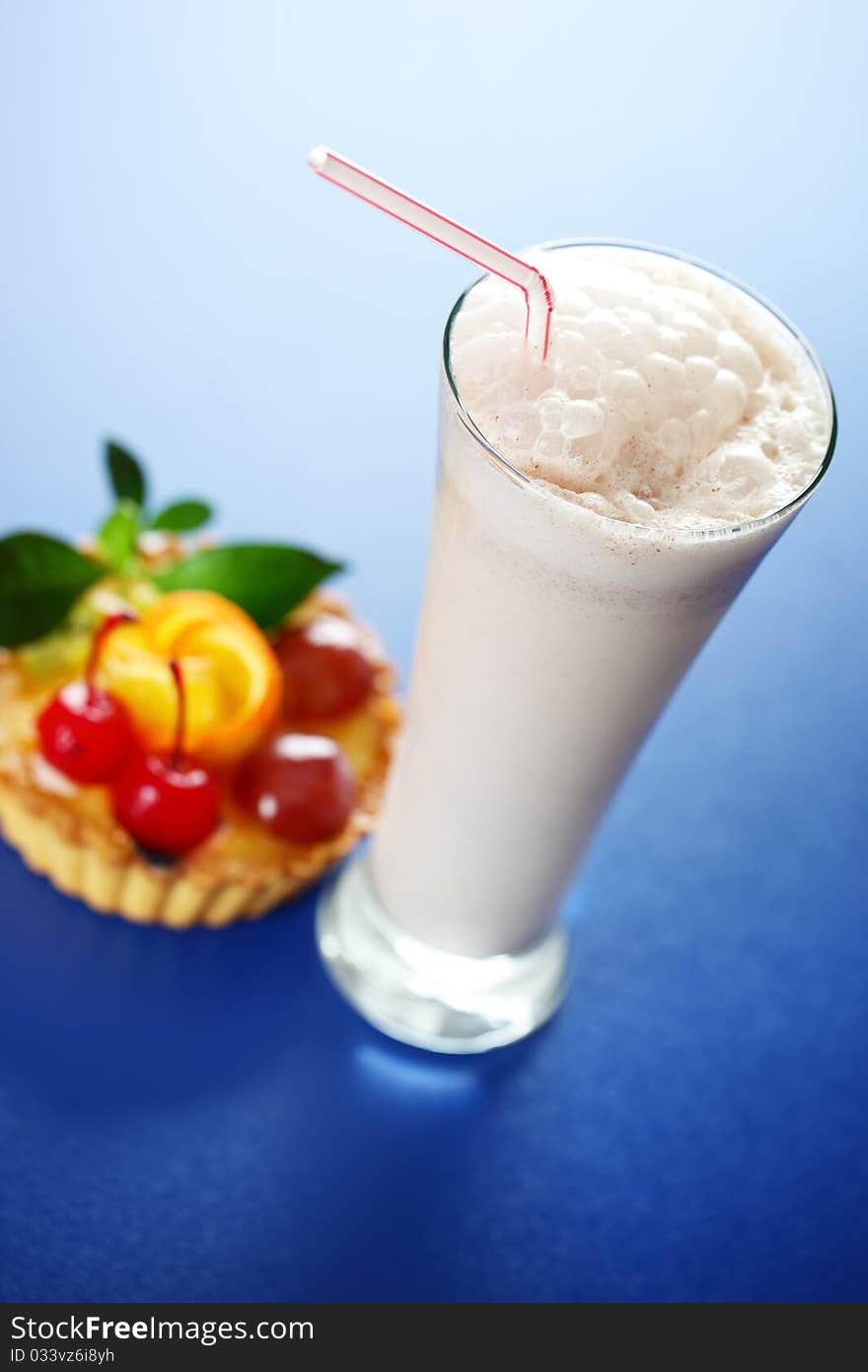 Milkshake and cake on a blue background. Milkshake and cake on a blue background