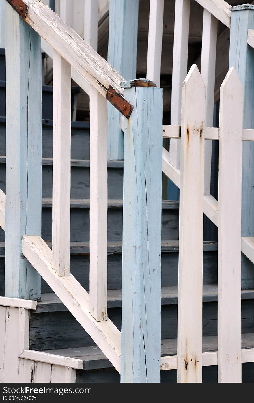 Wooden stair and rail fence, shown as architecture detail, geometric shape and white and light blue color.