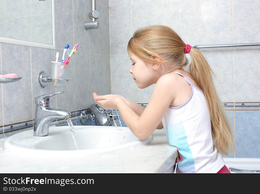 Little girl washing in bathroom