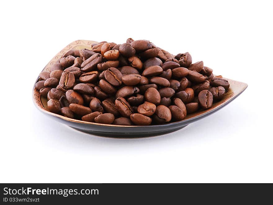 Coffee beans on a plate isolated on white background