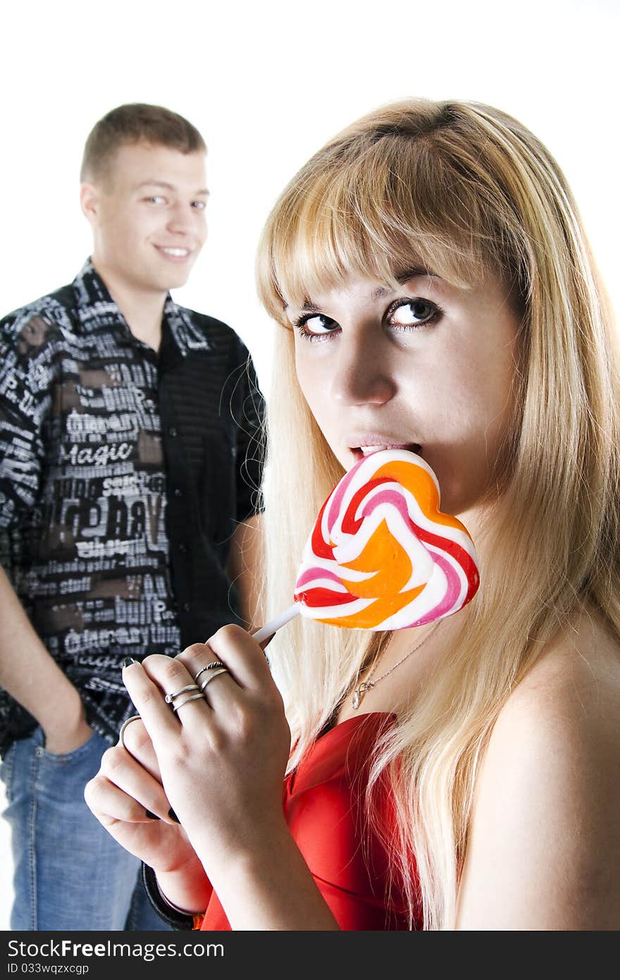 Young couple with heart-shaped lollypop