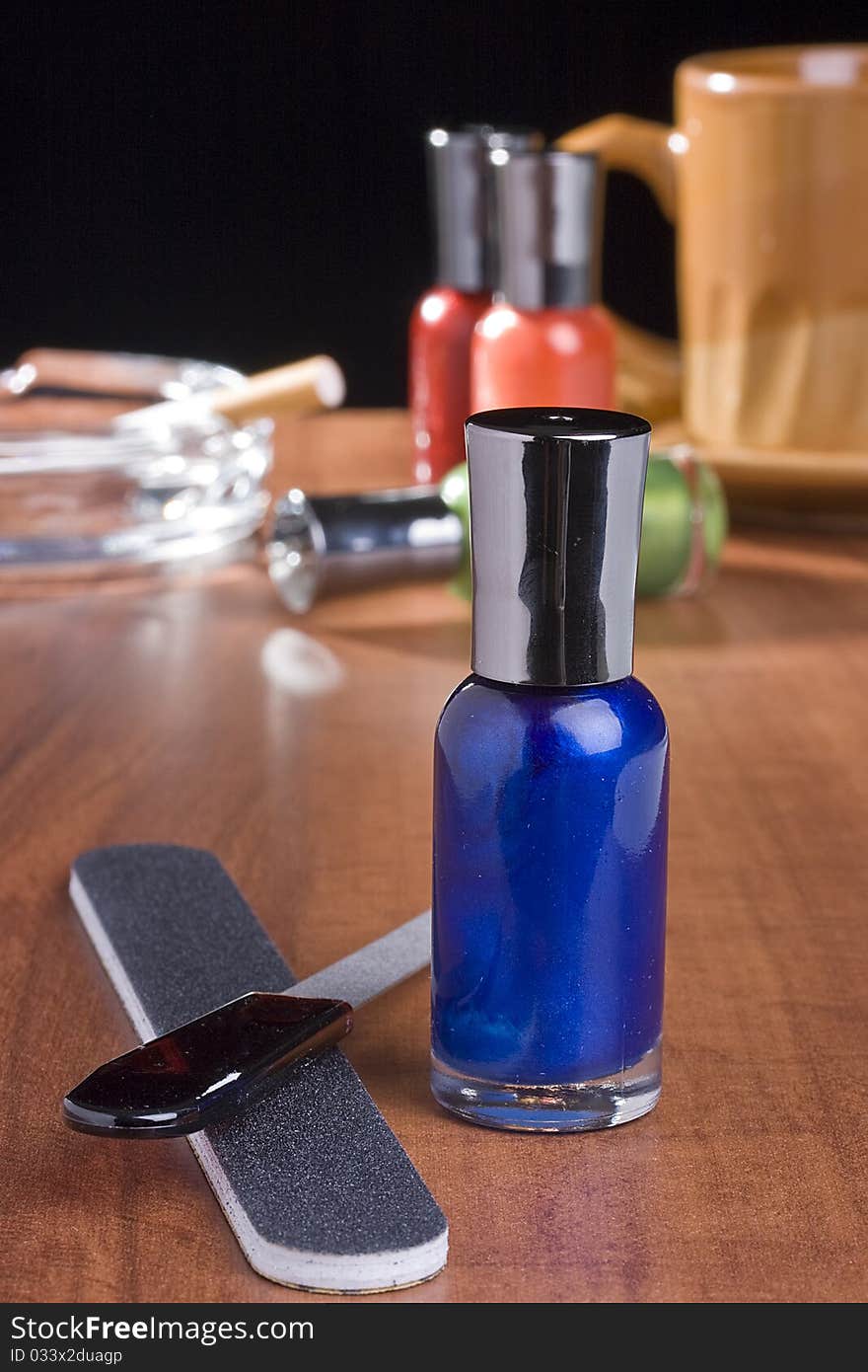 Nail accessories placed on a coffee table in front of a cup of coffee and an ashtray. Nail accessories placed on a coffee table in front of a cup of coffee and an ashtray.