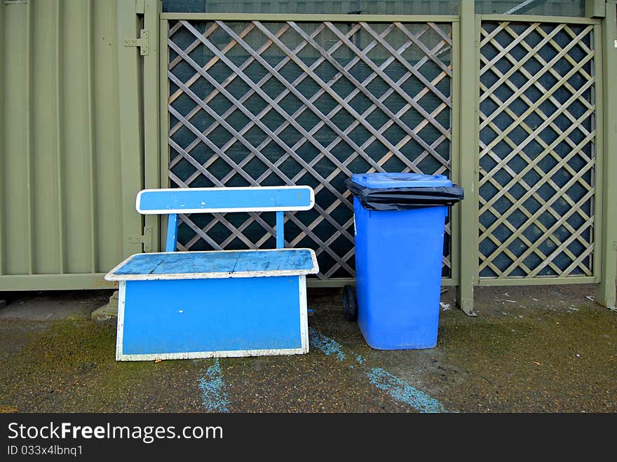 A blue bin for trash. A blue bin for trash