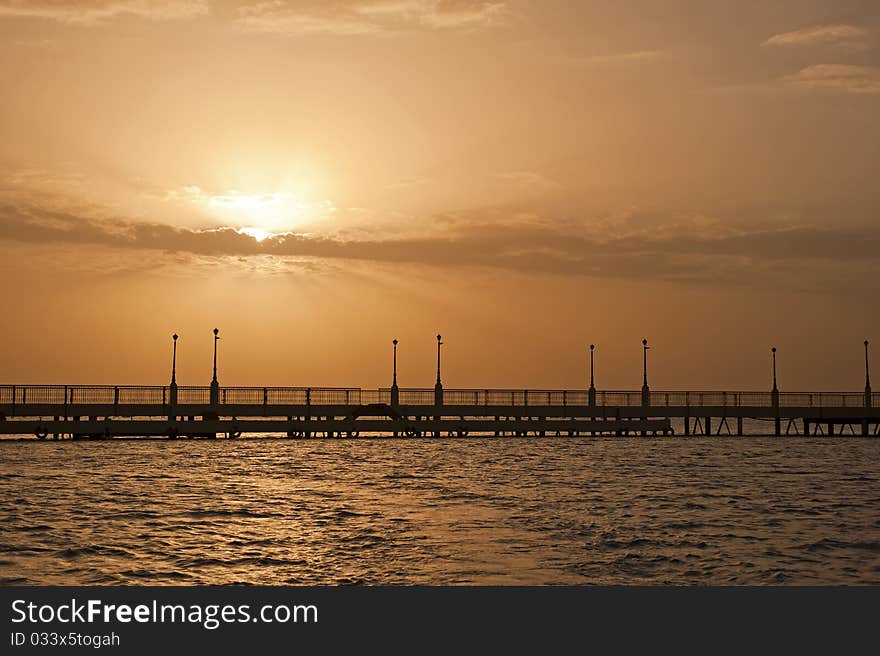 Sunrise over the ocean at a pier