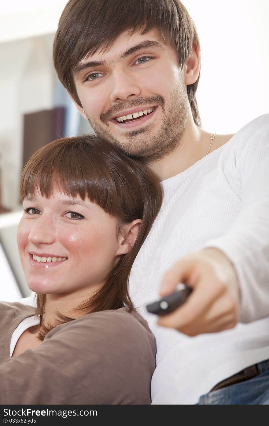 Happy young couple watching television at home. Happy young couple watching television at home